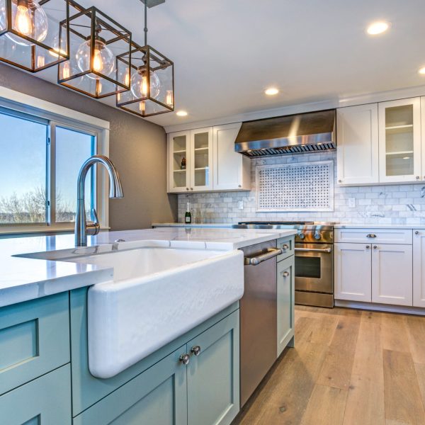 Beautiful kitchen room with green island and farmhouse sink.
